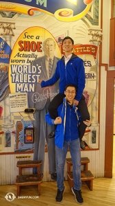 Kevin Diao (nahoře) a Tony Xue (dole) ukazují, že k dosažení vzrůstu nejvyššího muže světa (2,72 m) je potřeba jeden a půl tanečníka. Boty muže jsou vystaveny na Pike Place Market. (Fotil Daren Chou)