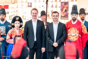 První fagotista Aleksander Velichko (vlevo) a pozounista Pavlo Baishev pózují s Korejci, kteří jsou oblečeni do tradičních oděvů monarchů. 