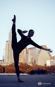 Mezitím se tanečnice Lily Wang dotýká špičkami oblohy s mrakodrapy v pozadí v Austinu, Texas. (Fotila tanečnice Michelle Wu)