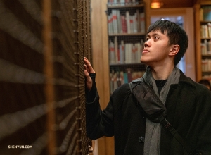 Monty Mou si prohlíží regály, které obsahují taneční a operní knihy v knihovně muzea Palais Garnier. (Fotil Andrew Fung)